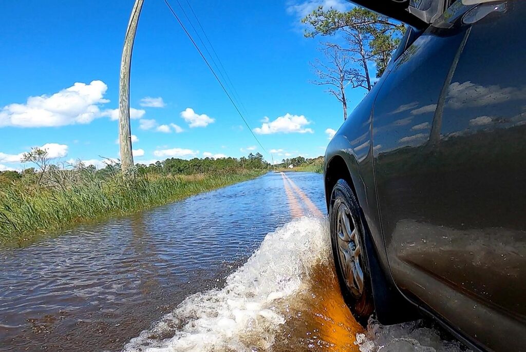 Tidal flooding pushes water across Jenkins Neck Road in Guinea