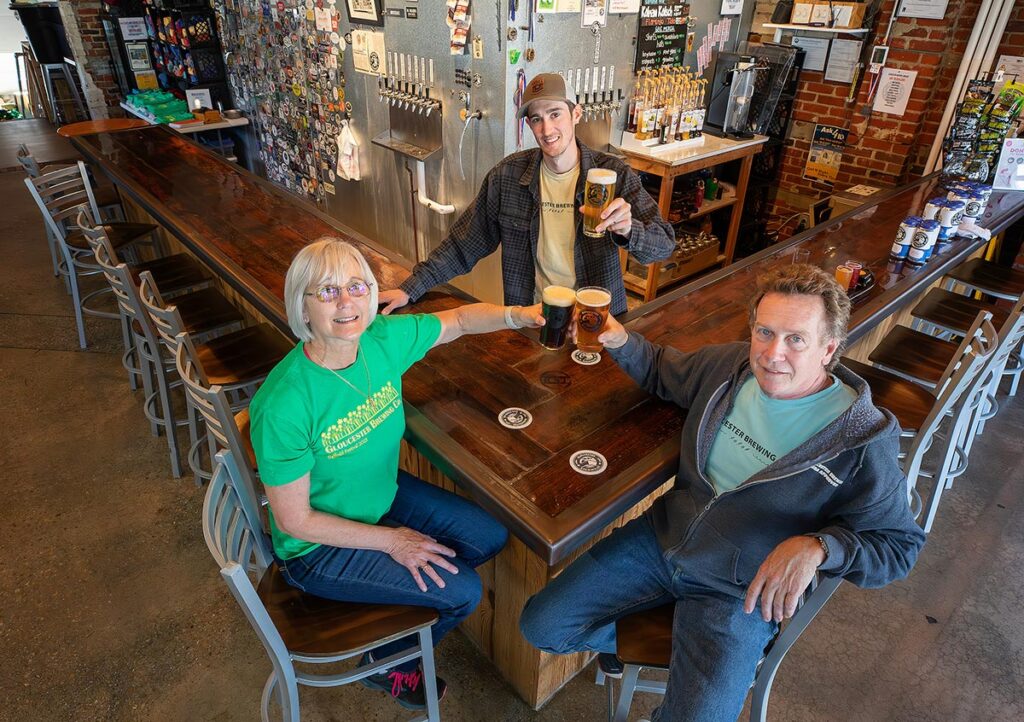 Gloucester Brewing owners at the bar toasting with beers