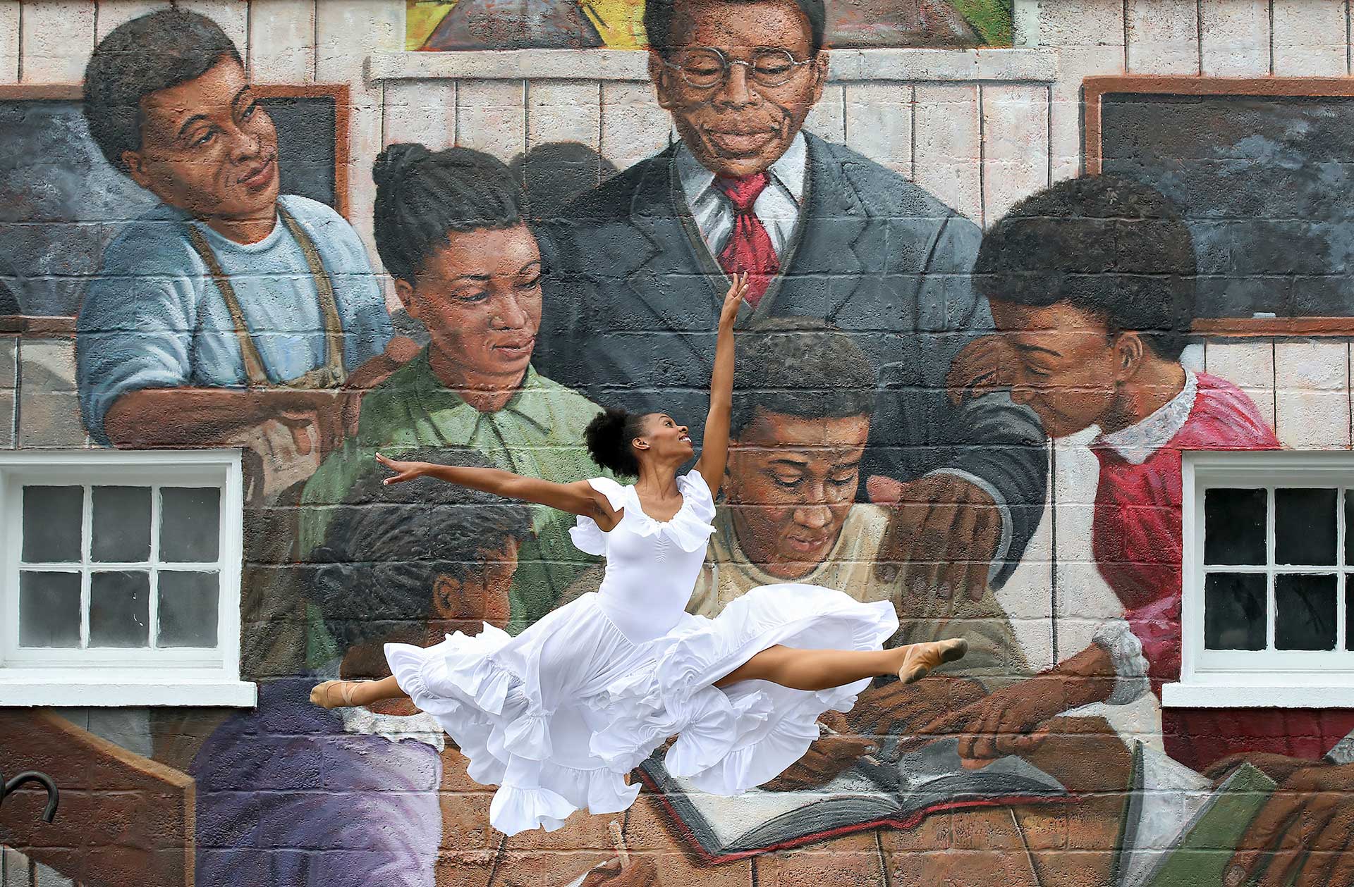 Dancer Kamilah Turner performs in front of the new TC Walker mural in downtown Gloucester